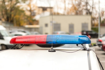 Roof of a police patrol car with flashing blue and red  lights, sirens and antennas