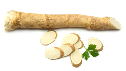 sliced horseradish root with parsley isolated on white background
