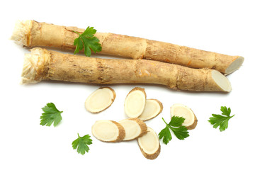 sliced horseradish root with parsley isolated on white background