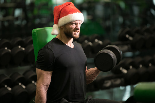 Gym, man in Santa hat pumping bicep