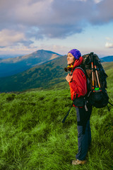 woman backpacker standing on the background of a mountainous area. Hiking in the mountains