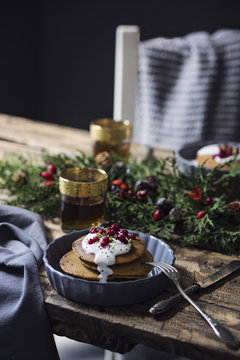 Pumpkin pancakes with yogurt cream and currant on wooden table