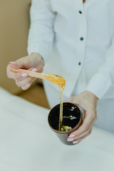 The procedure shugaring. In the hands of the beautician with the composition of the Bank shugaring. 
