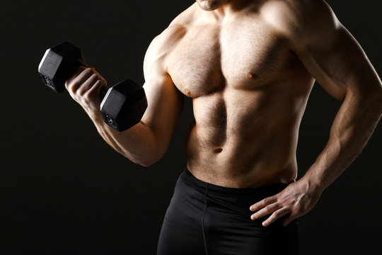 Powerful muscular man holding metal workout weight