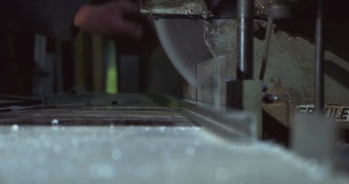 Close up of a metal cutting saw slicing through a piece of metal.