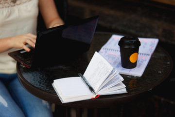 Obraz premium Female hands typing on a laptop. Woman freelancer writing outdoors.