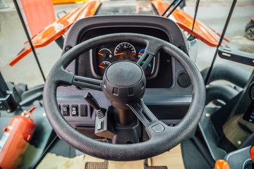 Inside modern agricultural tractor or harvester combine machine. Steering wheel. View from work...