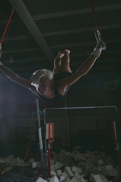 Male gymnast practicing on gymnastic rings