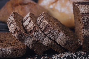 Assortment of baked bread on dark background.