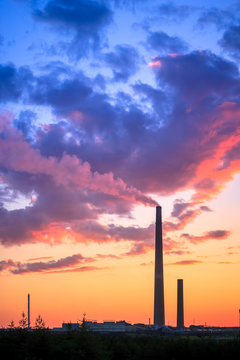 View of a smelter stack of a nickel plant showing the emission on the air with sunset sky as as background