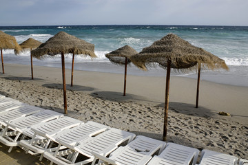 empty beach with straw umbrellas and beach chair