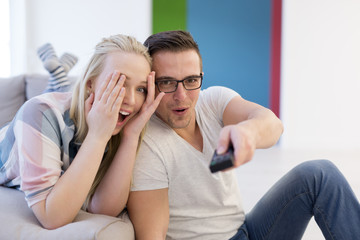 Young couple on the sofa watching television