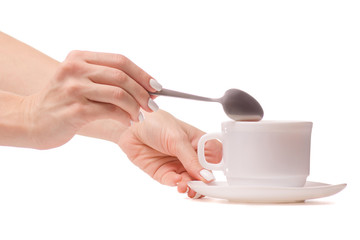 Cup and saucer with a teaspoon in hands tea coffee