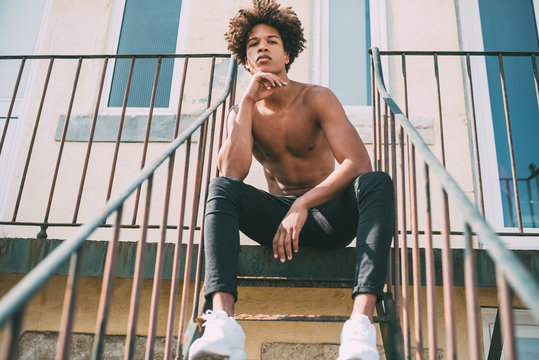 Shirtless Young Black Man Sitting In The Stairs