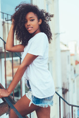 Young beautiful black woman on the stairs posing