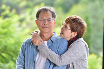 Portrait of happy romantic senior couple outdoor at the green nature background