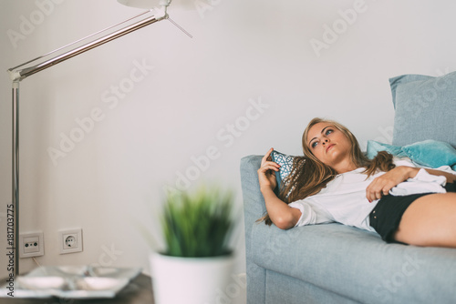 Young Beautiful Blonde Woman Lying Down On The Sofa Stock Photo