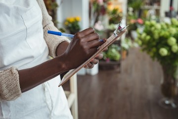 Female florist writing and making notes