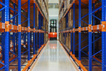 Electric forklift between large shelving in a modern storage building.