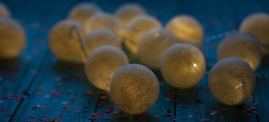 Christmas and New Year cotton light balls string on wooden table in the night