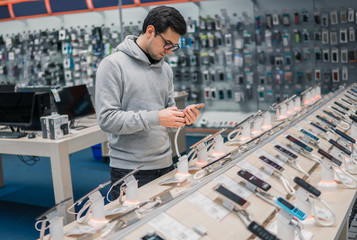 Smart customer choosing smartphone in the mobile phone shop. difficult decision. Various choice.