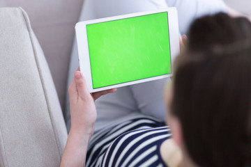 woman on sofa using tablet computer