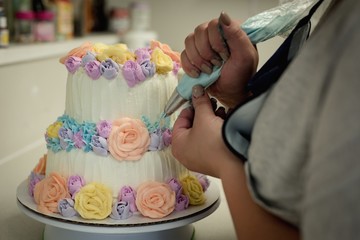 Woman decorating cake in the kitchen