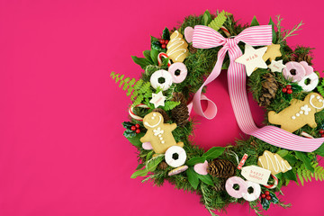 Christmas holiday wreath using fresh herbs, leaves, gingerbread, cookies, candy and gift tags, with copy space.