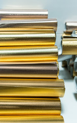 Stack of shiny golden gift-wrapping paper rolls for texture