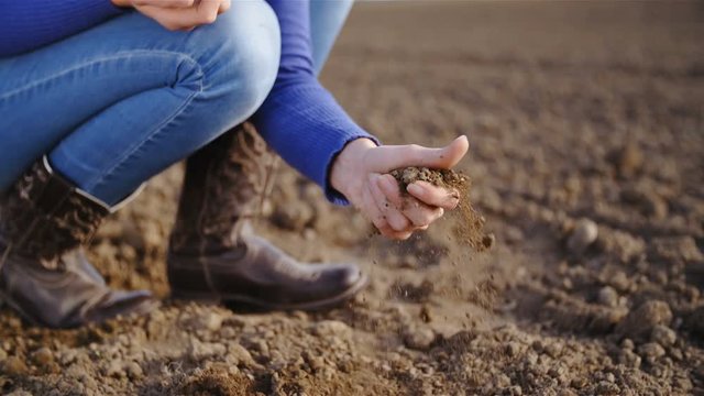 Farmer grabbing the soil dirt from the ground in slow motion 4K