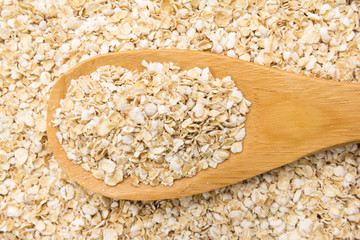 Oat cereal flake. Grains in wooden spoon. Close up.