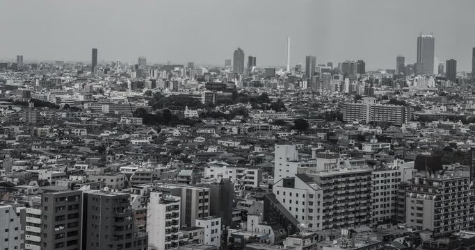 TOKYO, JAPAN – JUNE 2016 : Timelapse in black and white of central Tokyo cityscape with clouds and light moving over the city