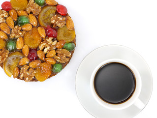 traditional fruitcake with fruits and nuts and a cup of coffee