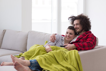 Young couple on the sofa watching television