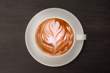 top view latte art coffee in white mug on wooden table