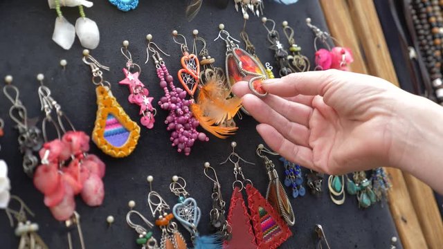 beautiful hippie decoration. the woman looks through the ornaments in the show-window of the street market. 4k, slow motion