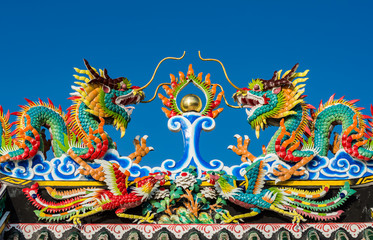 Twin chinese dragon statue on the roof of chinese temple
