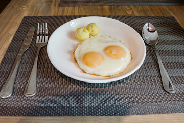 Twin fried eggs and mash potato on dish for breakfast.