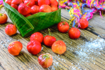 Thai Cherry in a bowl made from the leaves of the banana tree on wooden tables.