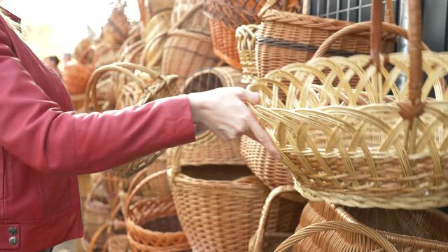 a woman chooses a wicker basket at a folk craft fair. 4k, slow motion