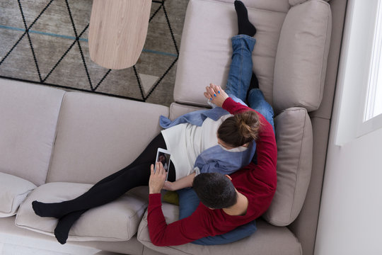couple relaxing at  home with tablet computers