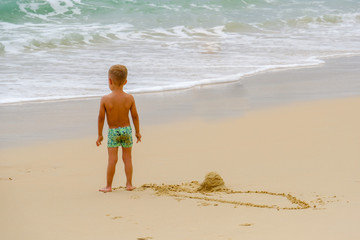 Little boy standing on the sand