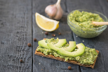 Toasted rye spread with cream of avocado slices.