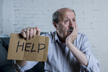 portrait of senior mature old man on his 60s at home couch alone feeling sad and worried suffering...
