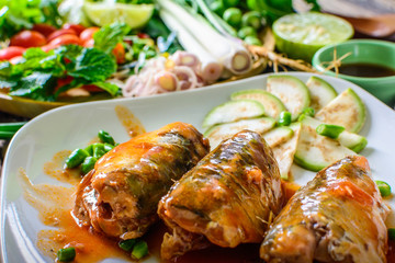 Mackerel with Tomato Sauce, Vegetables and herbs in a dish on the table. Yum Mackerel, Thai cuisine style.