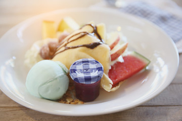 crepe cake with milk ice cream and watermelon melon grapes on wood background