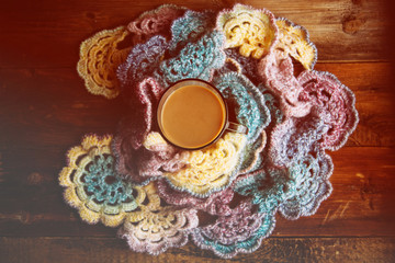 Hot chocolate in mug with marshmallows, wrapped in a woollen scarf