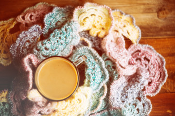 Hot chocolate in mug with marshmallows, wrapped in a woollen scarf