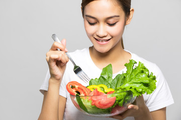 Young woman eating a salad.