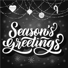Season's greetings brush hand lettering, on chalkboard background with snowflakes and garland. Vintage illustration. Can be used for holidays festive design.